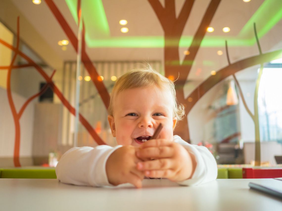 Kind glücklich und lachend im Kinderspielbereich des ALL IN Hotels Restaurants